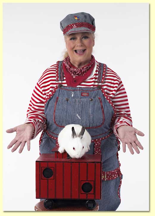 Photograph of Margaret Clauder as engineer Maggie with the magic caboose and Reader Rabbit.