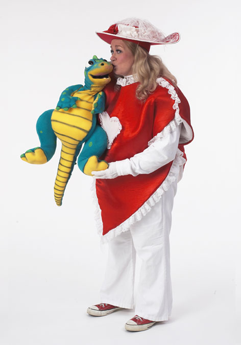 Picture of Margaret Clauder dressed as Lovey Dovey with Grouchy, a dinosaur puppet.