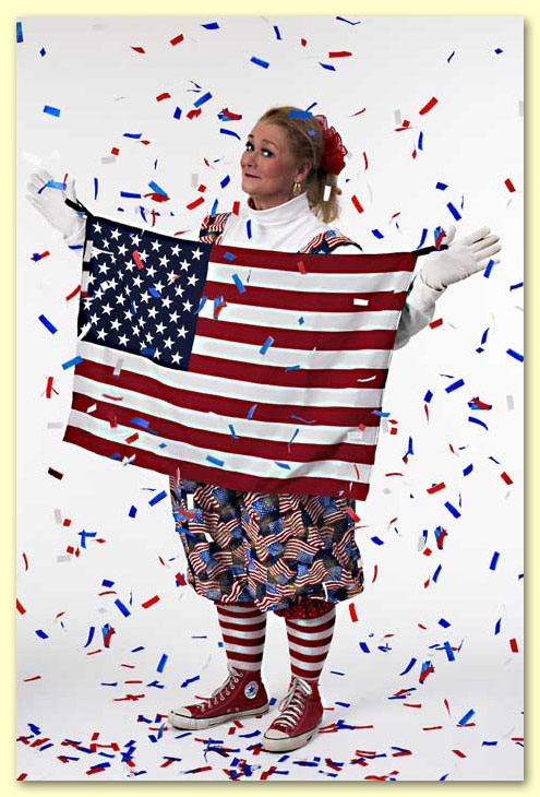 Photo of Margaret Clauder dressed as Patriotic Patty holding a United States flag in a shower of confetti.