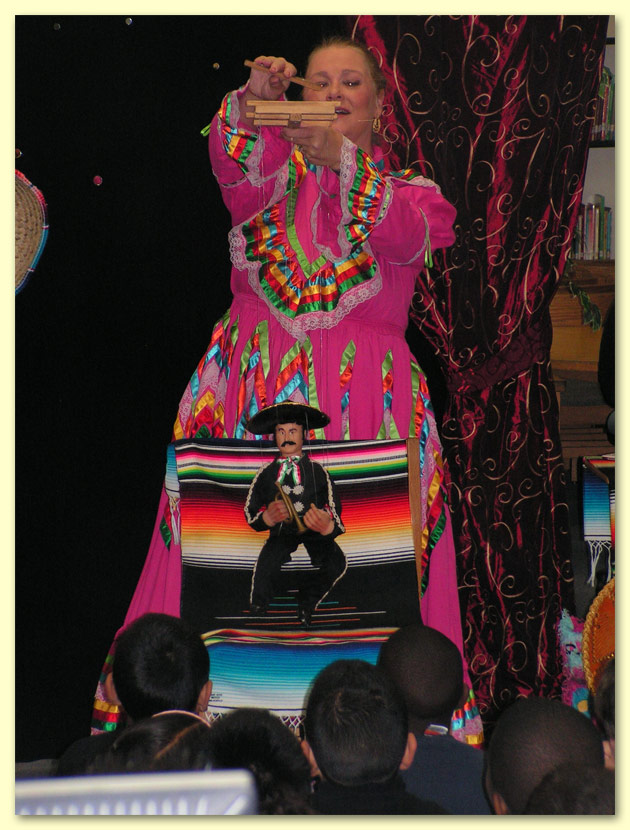 Thumbnail picture of Senorita Margarita, holding her dress with one hand, and a gold sombrero with the other.